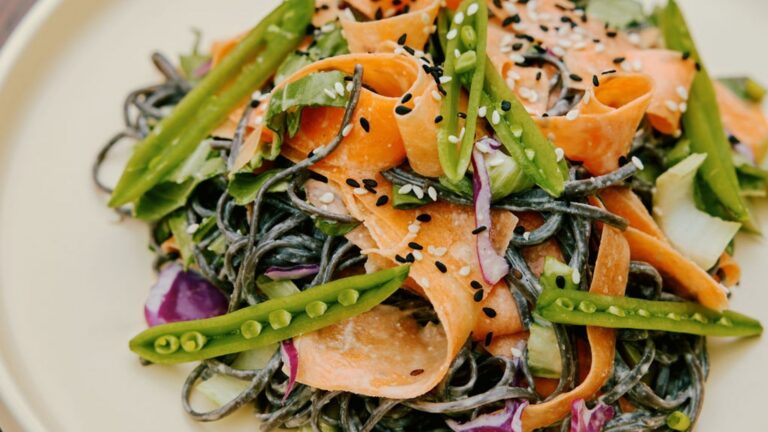 A close up photo shows a vegan dish from Purple Carrot featuring fresh vegetables and sesame seeds.