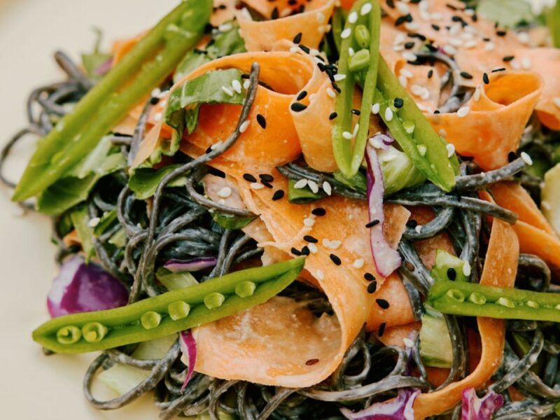 A close up photo shows a vegan dish from Purple Carrot featuring fresh vegetables and sesame seeds.