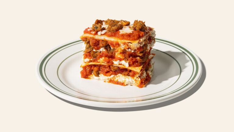 A slice of Purple Carrot's easy vegan lasagna is on a white plate.